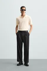 Polo color crema de punto, corte regular fit, con cuello solapa y abertura frontal.