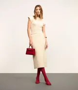 Pollera evasé midi de punto con cintura alta y elástico. Presenta un diseño con traspase delantero.