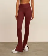 Pantalón deportivo tipo legging confeccionado en microfibra color bordó, con corte ajustado hasta la pantorrilla y terminación acampanada con abertura lateral.
