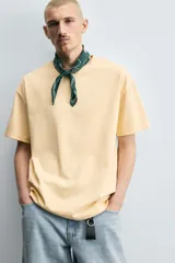 Camiseta color arena de algodón compacto, corte recto, cuello redondo y mangas cortas.