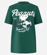 Remera manga corta verde con estampa de Snoopy jugando al tenis y texto "Peanuts" y "Racquet Club".