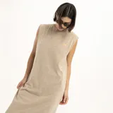 Vestido largo color beige, sin mangas, con cuello redondo y abertura lateral en el ruedo.