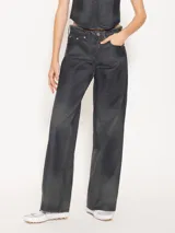 Pantalón de jean de corte recto y tiro medio-bajo, confeccionado en denim 100% algodón con proceso de coating simil cuero en tono azulado. Presenta desgastes estratégicos que dejan ver la base natural.