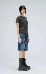 Bermuda de denim azul con efecto lavado, calce oversize y múltiples bolsillos tipo cargo.