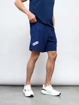 Bermuda de entrenamiento azul marino con escudo del Club Nacional de Football en la pierna izquierda. Confeccionada en tejido four-way stretch de poliéster y elastano.