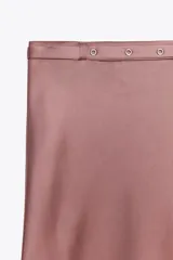 Falda midi de tiro alto confeccionada en tejido satinado color rosa viejo. Cintura con cinturón ajustable con hebilla metálica.