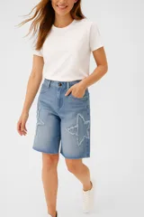 Bermuda de jean celeste con apliques de estrellas deshilachadas.