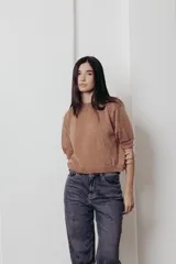 Sweater color dorado de tejido de punto suave con hilos metalizados, corte recto y mangas cortas con puño ajustado.