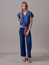 Blusa celeste de tencel con escote en V y botones. Tiene mangas cortas amplias con volados.