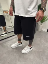 Bermuda deportiva negra de algodón, corte oversize con estampado pequeño en la pierna izquierda.