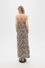 Vestido largo con estampado animal print en tonos beige y negro, breteles finos y corte holgado.