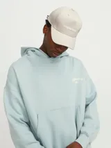 Gorra de béisbol color beige con logo bordado en el frente.