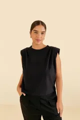 Camiseta negra sin mangas con hombreras y cuello redondo acanalado.