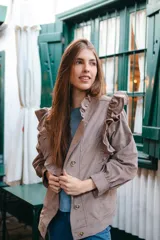 Campera bomber color marrón claro de pana con volados en las sisas y bolsillos grandes. Corte oversize.