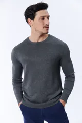 Buzo de punto gris oscuro con cuello redondo a la base.