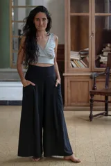 Pantalón palazzo negro de algodón con corte evasé, tiro alto, bolsillos laterales, elástico en la espalda y faja ancha.