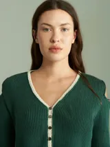 Saco de algodón verde con aberturas en hombros y codos, de corte entallado. Tiene cuello en V, botones pequeños y plaqueta de tejido puño color crudo.