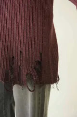 Sweater tejido color crudo, de manga larga con efecto desgastado y deshilachado en el ruedo y puños. Tiene cuello redondo y calce holgado.