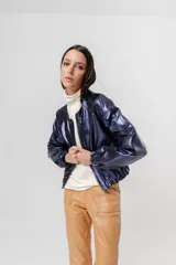 Bomber azul marino de cuero con mangas ranglán, bolsillos laterales, elástico en la cintura y cierre metálico delantero.