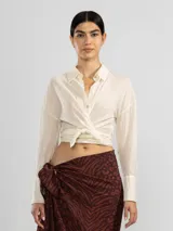 Camisa color crema de manga larga con lazo en la cintura y botones nacarados.