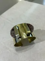 Brazalete rígido dorado con dos amatistas irregulares en los extremos.