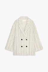 Blazer color crudo con rayas verticales negras con lentejuelas, cuello solapa y escote pico cruzado. Manga tres cuartos con vuelta y cierre cruzado con botones negros.