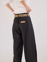 Pantalón negro de pierna ancha con tiro medio alto y pretina elastizada en la espalda. Presenta bolsillos plaque en delantera y espalda.