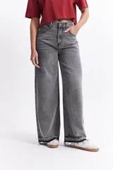 Pantalón jean wide leg de tiro alto, color gris lavado, con bolsillos delanteros y traseros, y ruedo desflecado.