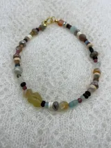 Collar corto de cuentas de piedras semipreciosas de diferentes colores y formas, con cierre de gancho dorado.