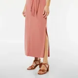 Vestido midi color rosa, sin mangas, con detalle de nudo en la cintura y abertura lateral.