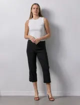 Pantalón capri negro de gabardina elastizada con pretina ancha elastizada y ruedo con aplique de crochet.