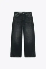 Pantalón de jean negro de tiro medio, corte amplio tipo baggy balloon, con cinco bolsillos y cierre frontal con cremallera y botón metálico.