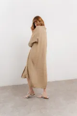 Vestido camisero midi color verde militar, de lino 100%, con silueta oversize, cuello camisero, mangas 3/4 con botón para ajustar y aberturas laterales.