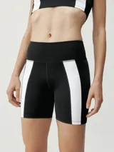 Short biker negro con bandas laterales blancas. Tejido Shapplex_B efecto moldeador. Incluye un bolsillo en la parte trasera de la cinturilla.