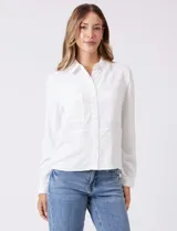 Camisa de crepe color fucsia, con cuello solapa, cierre frontal de botones y dos bolsillos aplicados en el pecho.