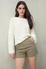 Sweater negro calado con diseño de líneas diagonales en relieve y mangas acampanadas.