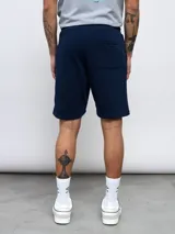 Bermuda deportiva negra de felpa con logo de Umbro bordado en rojo en la pierna derecha.