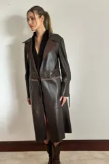 Trench de cuero ovino color chocolate con detalles en pasamanería de cueros en tonos tierra. Tiene lazos en mangas y espalda para entallar.