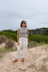 Chaleco tejido a mano en lana merino color gris y blanco, con cuello alto y sin mangas.