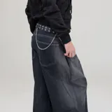 Cinturón negro de eco cuero con múltiples ojales metálicos y cadena plateada colgante.