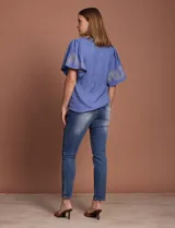 Blusa color beige de crepe marca Batía, con cuello a la base y escote en V. Presenta mangas cortas amplias con bordados.