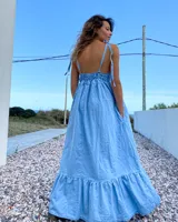 Maxi vestido celeste de jean con breteles regulables y bolsillos laterales.