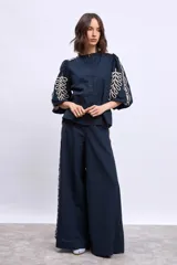 Blusa azul marino con cuello mao, mangas 3/4 abullonadas y bordados en color crema en hombros y mangas.