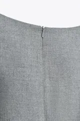 Vestido mini gris con cuello barco y sin mangas. Falda con tablas en color blanco. Cierre trasero con cremallera oculta.