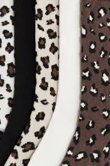 Pack de siete pares de medias de caña media, con diseños variados: dos pares lisos en color crema y blanco, un par negro liso, y cuatro pares con estampado de leopardo en diferentes combinaciones de colores.