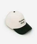 Gorra de béisbol bicolor, con cuerpo blanco y visera verde oscuro. Tiene bordado el texto "Central Park" en verde.