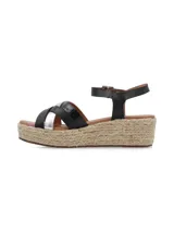 Sandalias con plataforma de yute, tiras cruzadas de cuero negro y plateado, y pulsera al tobillo con hebilla metálica.