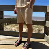 Short de tejido color blanco con logo bordado en negro en la pierna izquierda.