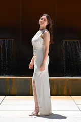 Vestido largo color blanco hueso, de fiesta, con escote redondo, sin mangas y abertura lateral en la falda.