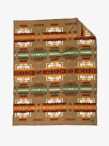 Manta de lana tejida con diseño geométrico en tonos tierra, rojo, naranja, amarillo y verde, sobre fondo marrón claro. El patrón es repetitivo y simétrico, con motivos que recuerdan a diseños nativos americanos.